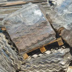 Montones de placas onduladas de fibrocemento, listas para retirar uralita.