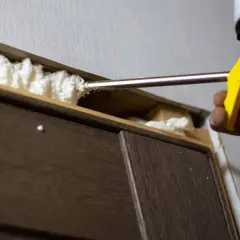 Aplicando espuma de poliuretano para sellar huecos. Si necesitas saber como quitar la espuma de poliuretano, este es el primer paso.