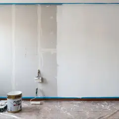 Pintar pladur es un proceso que requiere paciencia. Aquí, una pared a medio pintar, con rodillo y brocha listos para continuar.