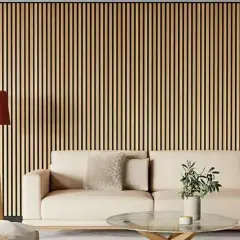 Una pared con listones de madera verticales, ideal para quienes buscan ideas sobre como poner listones de madera en la pared. Un sofá beige y una lámpara roja completan la escena.