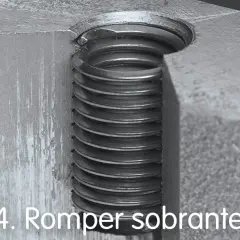 Detalle de un tornillo pasado de rosca, con las espiras metálicas visibles y dañadas.