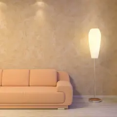 Sofá naranja junto a una lámpara de pie, con una pared texturizada que parece estucar una pared con un acabado rústico.