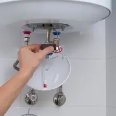 Mano ajustando componente de calentador de agua, parte de un tutorial sobre como limpiar un termo por dentro.
