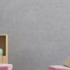 Estantería de madera con tazas, jarrón y un cojín sobre un sofá rosa. La pared tiene un acabado de gotelé, ideal para aplicar papel pintado sobre gotele.