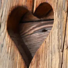 Corazón tallado en madera rústica, mostrando el encanto del envejecer madera.