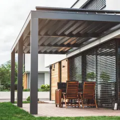 Elegante pérgola bioclimática con techo de lamas orientables. Los inconvenientes podrían ser el mantenimiento de las lamas y la posible acumulación de agua.