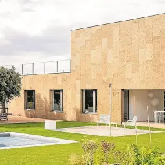 Fachada moderna con aislamiento acústico de corcho, piscina y jardín.