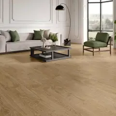 Elegante salón con sofá gris, sillón verde y un moderno revestimiento del suelo de madera clara que aporta calidez.