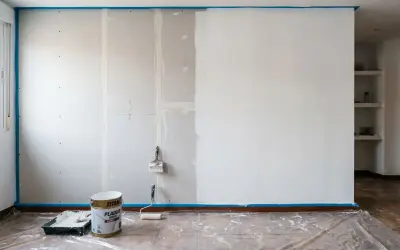Pintar pladur es un proceso que requiere paciencia. Aquí, una pared a medio pintar, con rodillo y brocha listos para continuar.