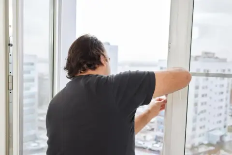Hombre ajustando burlete para como aislar ventanas correderas. Mejora el aislamiento térmico de tu hogar.