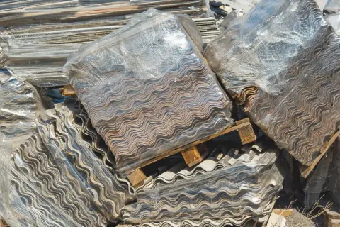 Montones de placas onduladas de fibrocemento, listas para retirar uralita.