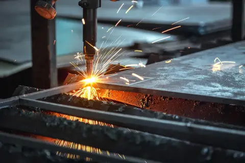Chispa de corte de acero. Una máquina industrial realiza un corte de acero, lanzando chispas brillantes y creando un espectáculo de luz y calor.
