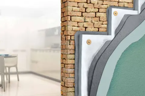 Corte de pared mostrando aislamiento y trasdosado pladur sobre ladrillo.
