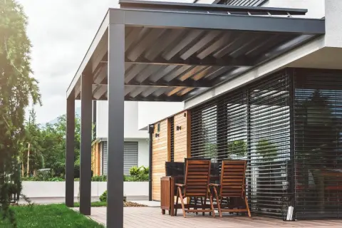 Elegante pérgola bioclimática con techo de lamas orientables. Los inconvenientes podrían ser el mantenimiento de las lamas y la posible acumulación de agua.