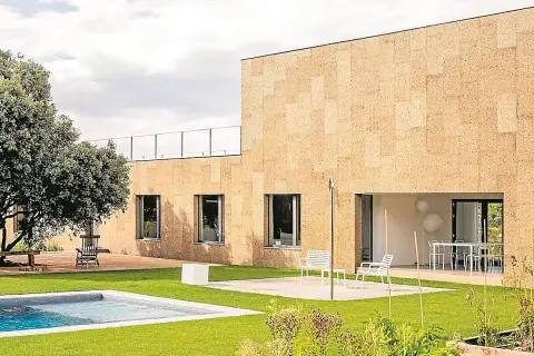 Fachada moderna con aislamiento acústico de corcho, piscina y jardín.