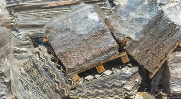 Montones de placas onduladas de fibrocemento, listas para retirar uralita.
