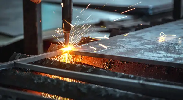 Chispa de corte de acero. Una máquina industrial realiza un corte de acero, lanzando chispas brillantes y creando un espectáculo de luz y calor.