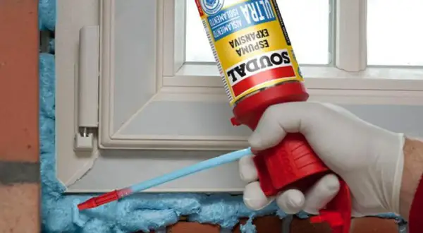 Aplicación de espuma de poliuretano expandido para aislar un marco de ventana.