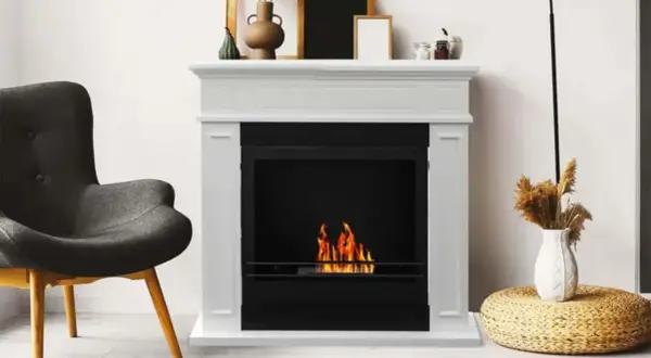 Chimenea blanca con fuego encendido. Si tu chimenea hace humo, aquí tienes consejos sobre como arreglar una chimenea que hace humo.