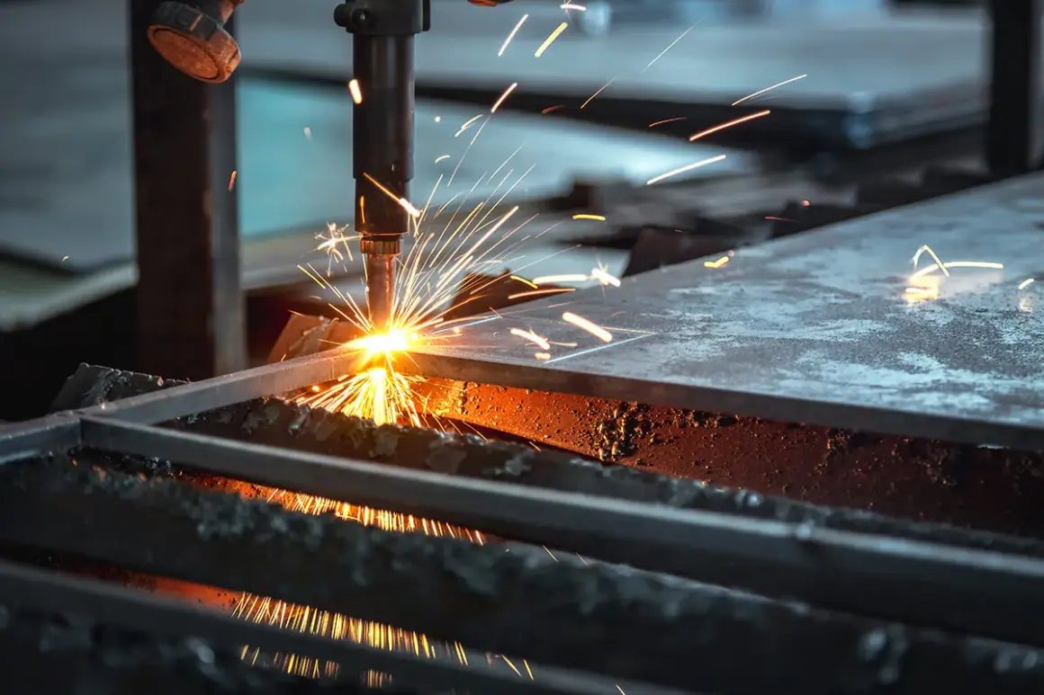 Chispa de corte de acero. Una máquina industrial realiza un corte de acero, lanzando chispas brillantes y creando un espectáculo de luz y calor.