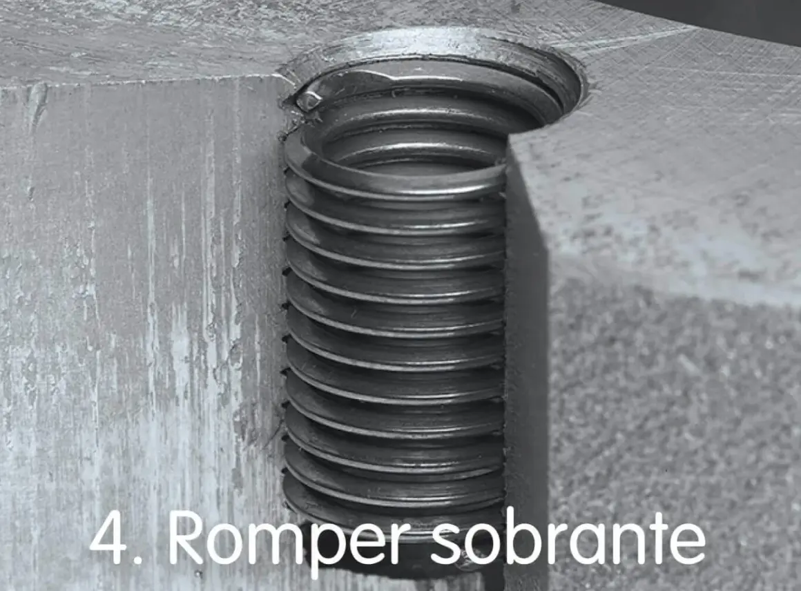Detalle de un tornillo pasado de rosca, con las espiras metálicas visibles y dañadas.