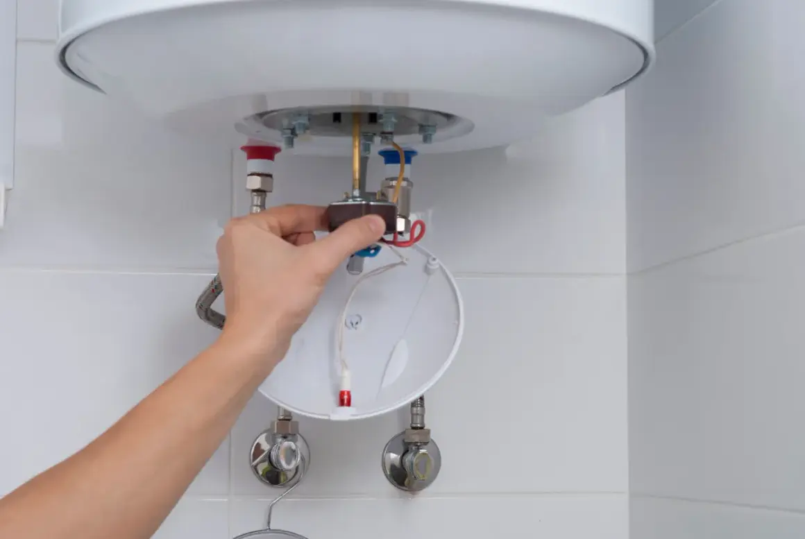Mano ajustando componente de calentador de agua, parte de un tutorial sobre como limpiar un termo por dentro.