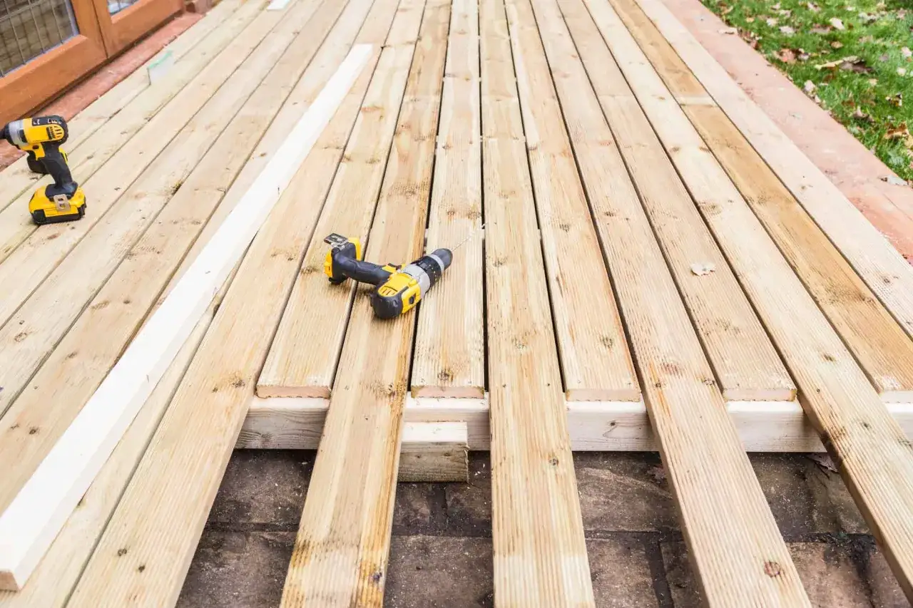 Construcci&oacute;n de terraza con madera natural, ideal para exterior. Taladros y listones listos para el montaje.