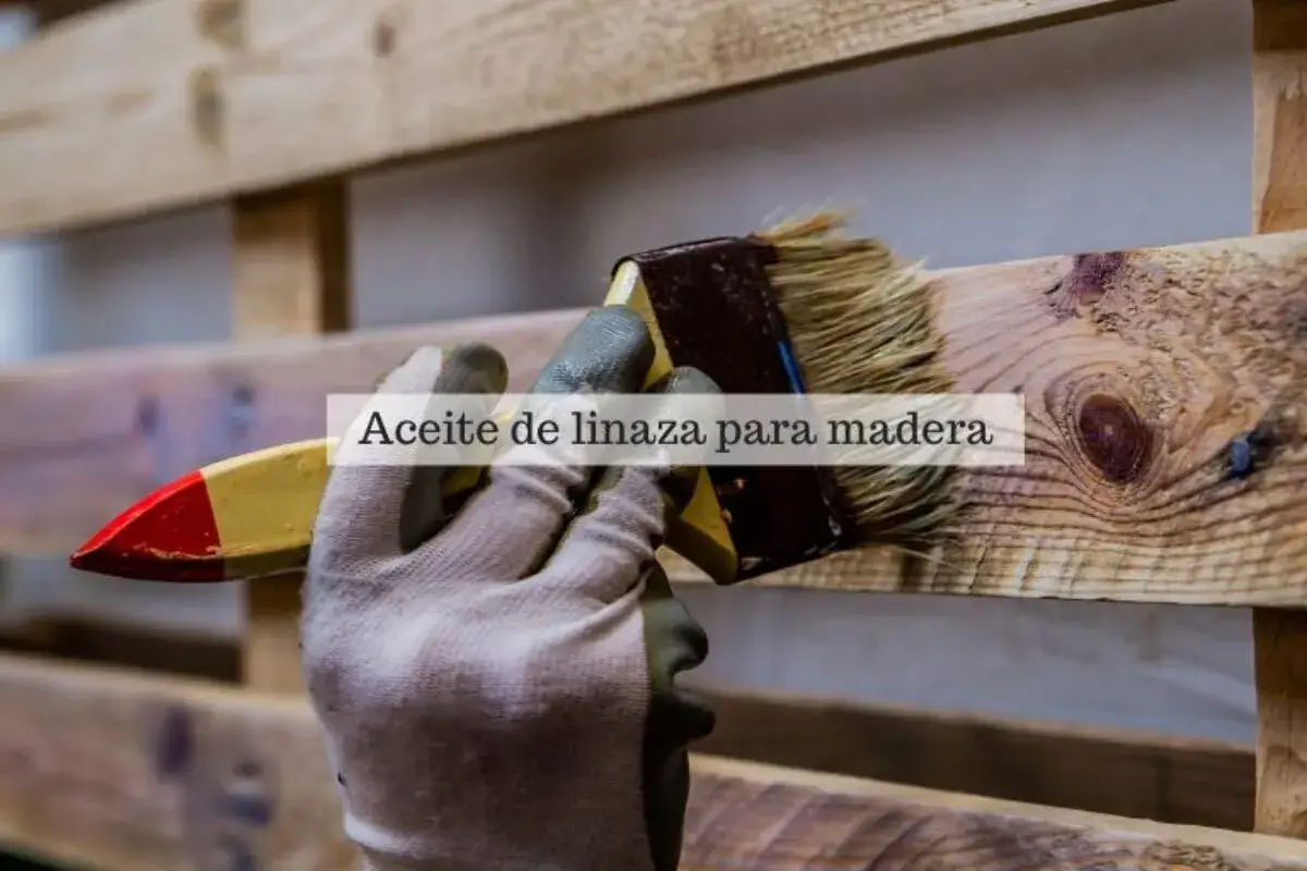 Mano enguantada aplica aceite de linaza a madera, protegiéndola y realzando su veta. Descubre para qué sirve el aceite de linaza en la madera.