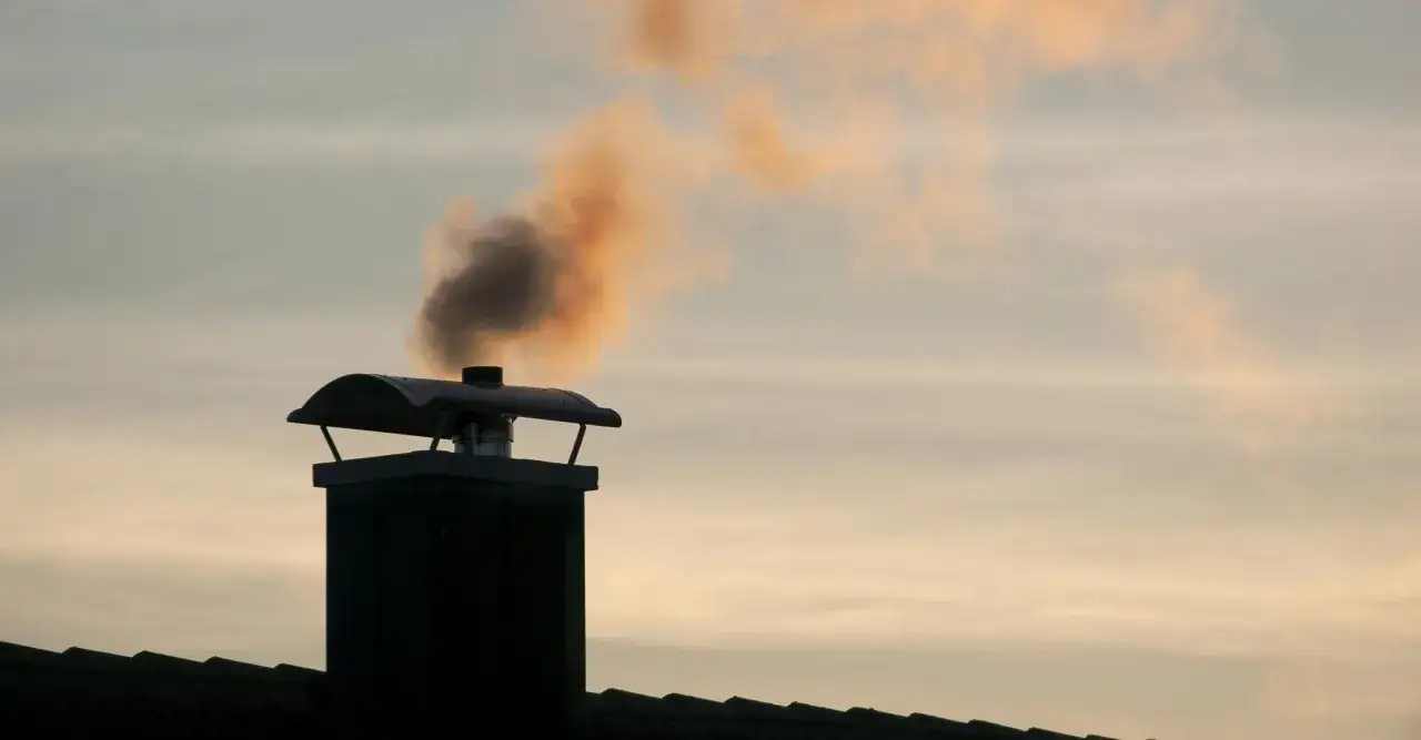 Humo saliendo de una chimenea. Si tu chimenea hace humo, aquí te explicamos como arreglar una chimenea que hace humo.