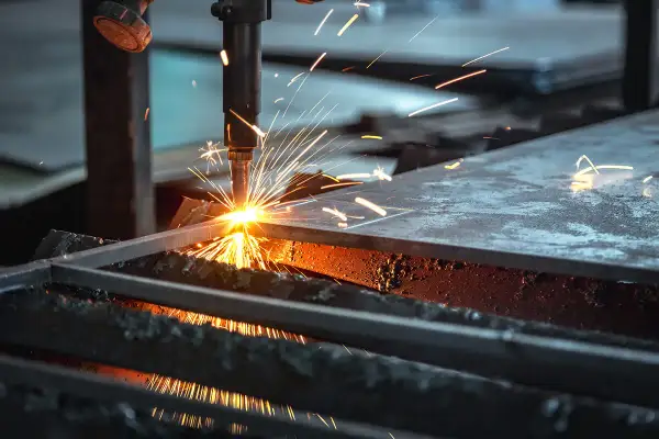Chispa de corte de acero. Una máquina industrial realiza un corte de acero, lanzando chispas brillantes y creando un espectáculo de luz y calor.