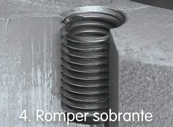 Detalle de un tornillo pasado de rosca, con las espiras metálicas visibles y dañadas.