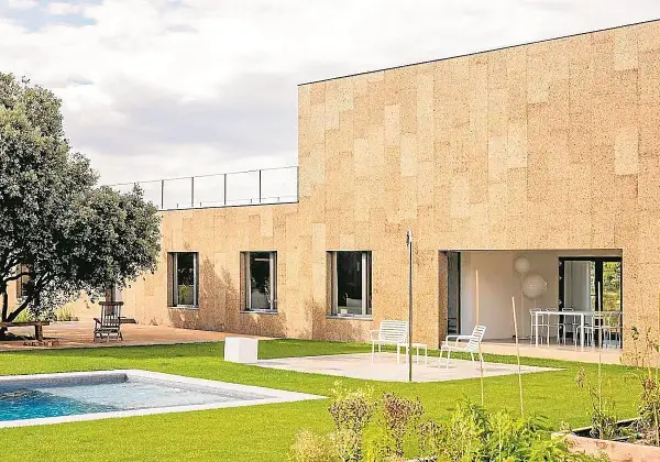 Fachada moderna con aislamiento acústico de corcho, piscina y jardín.