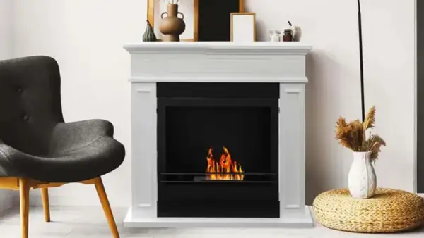 Chimenea blanca con fuego encendido. Si tu chimenea hace humo, aquí tienes consejos sobre como arreglar una chimenea que hace humo.